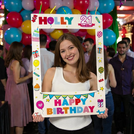 Person holding a birthday-themed photo frame with colorful balloons in the background